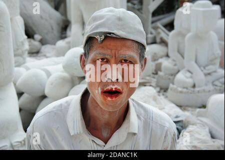 Le fantôme un sculpteur birman en marbre recouvert de blanc fin poudre de marbre sa bouche se tachait de rouge de noix de bétel à mâcher lui donnant un aspect hanté fantomatique Banque D'Images