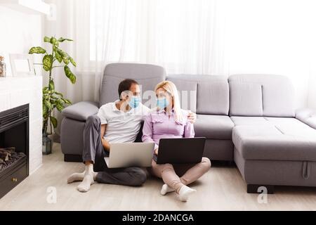 Une jeune famille travaille à domicile à l'aide d'ordinateurs. Couple travaillant à distance en ligne pendant la quarantaine. Concept rester à la maison. Virus Corona covid-19 Banque D'Images