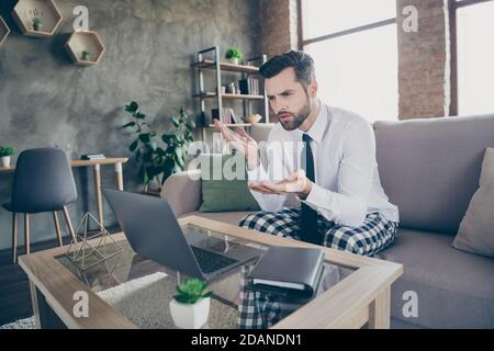 Photo de l'élégant marketter homme assis divan blanc chemise noir cravate cravate sommeil nuit vêtements travail distant ordinateur portable discuter des partenaires stratégie de démarrage des employés Banque D'Images