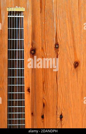 Vue aérienne du cou d'une guitare de voyage sur fond rustique en bois. Banque D'Images