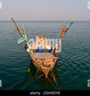 Vue de bout d'un bateau de pêche traditionnel amarré dans les eaux calmes de la mer en Asie, avec paniers, filets et cordes. Banque D'Images