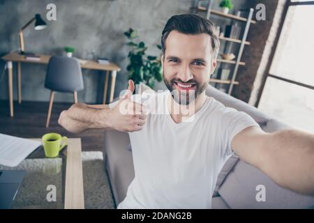 Auto-portrait de son beau attrayant gai gai gars il gérant assis sur un divan travaillant à distance en ligne avec une publicité à titre de huthbup c'est cool Banque D'Images