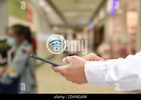 Homme main à l'aide d'un smartphone mobile avec icône wi-fi. Idée de réseau social de communication d'entreprise. Banque D'Images
