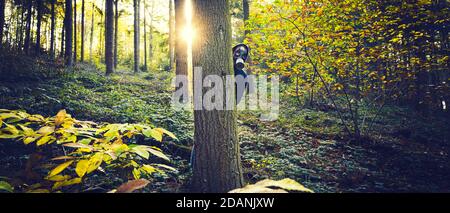 Homme avec masque à gaz en forêt au lever du soleil Banque D'Images