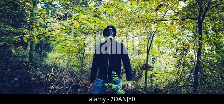 Homme avec masque à gaz en forêt à l'automne Banque D'Images