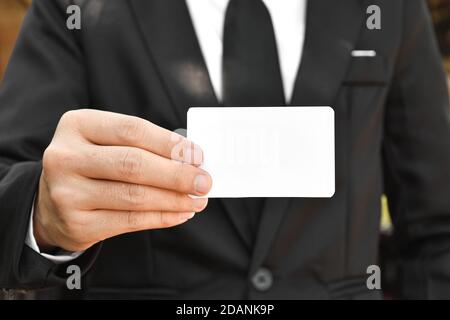 Gros plan d'un homme d'affaires tenant un morceau de papier blanc. Main de mise au point sélective. Banque D'Images