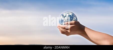 Concept de journée de l'environnement, Globe dans les mains des enfants sur fond bleu ciel. Sauvegarde de la terre. Éléments de cette image fournis par la NASA Banque D'Images