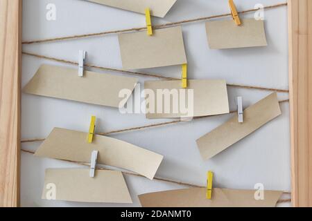 Carte de notification vierge, papier marron et clip en bois. Suspension de papier pour le texte ou votre dessin. Banque D'Images