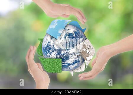 Recyclez le symbole et la terre entre les mains sur fond vert. Concept d'environnement. Éléments de cette image fournis par la NASA Banque D'Images