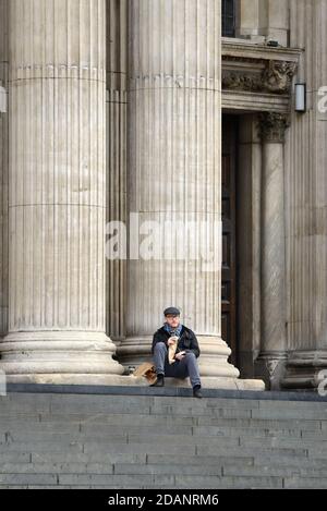 Londres, Angleterre, Royaume-Uni. Homme mangeant son déjeuner sur les marches de la cathédrale Saint-Paul traitant le second confinement de la COVID, novembre 2020. Banque D'Images