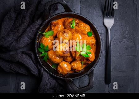 Boulettes de viande avec sauce tomate dans une casserole noire Banque D'Images