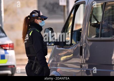 Vendrell, Espagne. 20 mars 2020. Un agent de police demande la documentation des occupants d'un véhicule pendant les contrôles de confinement.la police locale d'El Vendrell effectue des contrôles de confinement municipaux de fin de semaine, décrétés par le Gouvernement de Catalogne en raison de la crise sanitaire de Covid-19. Les gens, du vendredi à 0600 h au lundi à 6 h 00, ne peuvent quitter leur municipalité résidentielle, sauf quelques exceptions limitées. Crédit : Ramon Costa/SOPA Images/ZUMA Wire/Alamy Live News Banque D'Images