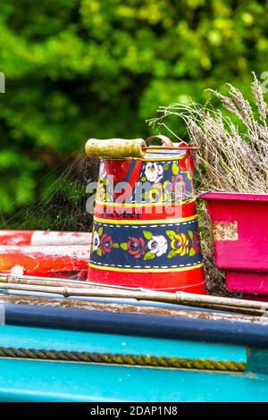 Seau sur le dessus d'un bateau étroit peint dans le style folklorique roses & châteaux, Grand Union canal, Colne Valley, Royaume-Uni Banque D'Images