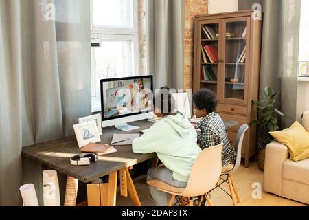 Les élèves sont assis devant le moniteur d'ordinateur et écoutent leur enseignant Banque D'Images