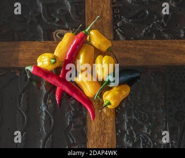 Poivrons jaunes, rouges et verts sur une table rustique Banque D'Images