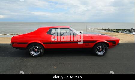 Ford Mustang rouge classique stationné sur la promenade du front de mer. Banque D'Images