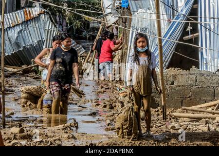 Rizal, Philippines. 14 novembre 2020. Les résidents portent leurs effets personnels récupérés de la maison endommagée après l'inondation provoquée par le typhon Vamco dans la province de Rizal, aux Philippines, le 14 novembre 2020. Le typhon Vamco a traversé l'île principale des Philippines, Luzon, de mercredi à jeudi, déclenchant des inondations soudaines et des glissements de terrain dans de nombreuses régions, laissant au moins 53 morts. Crédit: Rouelle Umali/Xinhua/Alamy Live News Banque D'Images