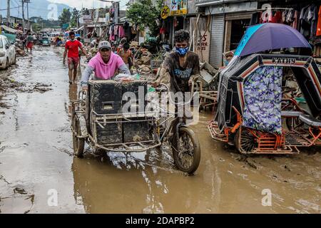Rizal, Philippines. 14 novembre 2020. Les résidents transfèrent leurs effets personnels récupérés de leur domicile endommagé après l'inondation provoquée par le typhon Vamco dans la province de Rizal, aux Philippines, le 14 novembre 2020. Le typhon Vamco a traversé l'île principale des Philippines, Luzon, de mercredi à jeudi, déclenchant des inondations soudaines et des glissements de terrain dans de nombreuses régions, laissant au moins 53 morts. Crédit: Rouelle Umali/Xinhua/Alamy Live News Banque D'Images