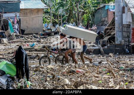 Rizal, Philippines. 14 novembre 2020. Les résidents portent leurs effets personnels récupérés de leur domicile endommagé après l'inondation provoquée par le typhon Vamco dans la province de Rizal, aux Philippines, le 14 novembre 2020. Le typhon Vamco a traversé l'île principale des Philippines, Luzon, de mercredi à jeudi, déclenchant des inondations soudaines et des glissements de terrain dans de nombreuses régions, laissant au moins 53 morts. Crédit: Rouelle Umali/Xinhua/Alamy Live News Banque D'Images