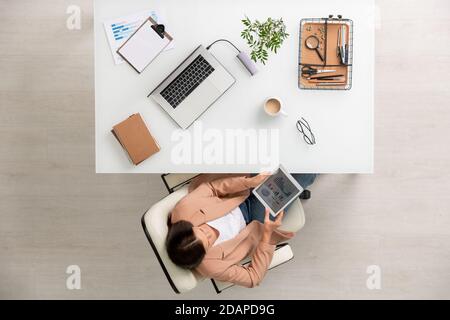 Aperçu de la jeune femme d'affaires avec des graphiques et des diagrammes d'analyse de tablette Banque D'Images