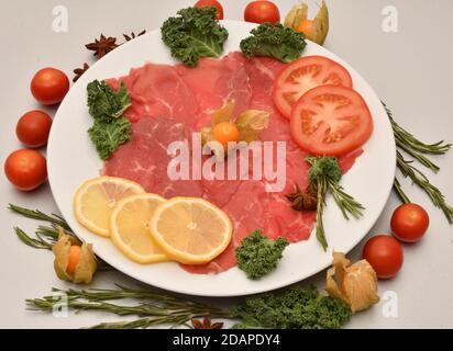 Plat de carpaccio de morceaux finement tranchés (tranches) filet de bœuf cru Banque D'Images