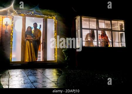 14 novembre 2020. Nikil Kenth avec sa femme Sunie, et sa belle-mère et sœur Deepali et Surbhi, fêtent le dernier jour de Diwali - ou Festival of Light - chez eux à Solihull, West Midlands, Royaume-Uni. En raison des conditions actuelles de confinement de Covid en Angleterre, l'atmosphère normalement sociable et de fête a été sévèrement limitée, et les communautés hindoues du Royaume-Uni sont forcées de célébrer et de payer leurs dévotions chez elles avec leurs bulles familiales. Crédit : Peter Lophan/Alay Live News Banque D'Images