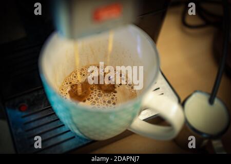 La machine à café prépare un café pour le cappuccino (avec flou) Banque D'Images