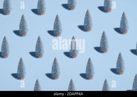 Motif d'arbres de Noël argentés sur fond bleu pastel. Style minimaliste. Concept de Noël ou de nouvel an. Banque D'Images