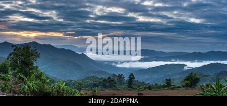 Vallée isolée dans les montagnes du Laos du Nord, coucher de soleil ciel spectaculaire. Village tribal d'Akha destination de voyage pour trekking tribal, groupe ethnique d'Akha et m Banque D'Images