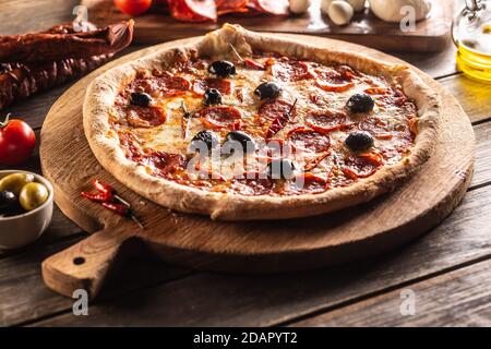 Pizza diavola repas italien traditionnel avec piment épicé de salami peperoni et olives Banque D'Images