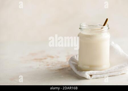 Petit déjeuner sain. Yogourt thermofermenté à base de lait dans un pot en verre avec un espace pour le texte sur la gauche. Banque D'Images