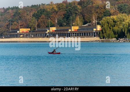 Sports d'automne à Berlin : un kayakiste solitaire pagaie devant le lido de Wannsee Banque D'Images