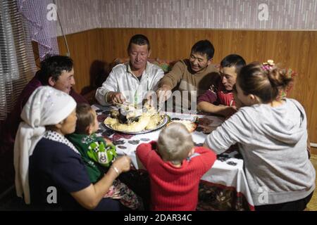 SPAI Bashakhan, chef d'une famille nomade dans les montagnes de l'Altaï, dîner ensemble dans les quartiers d'hiver, province d'Olgii, Mongolie Banque D'Images