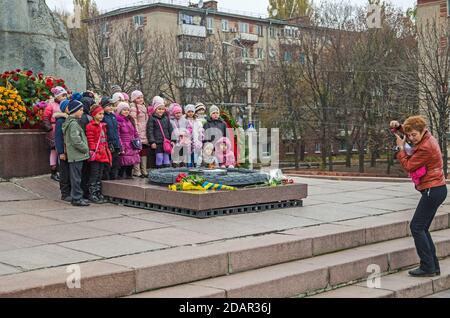 L'éducateur prend des photos d'enfants lors d'une excursion au monument des soldats tombés de la Seconde Guerre mondiale 25 octobre 2013. Dnipro, Ukraine Banque D'Images