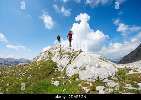 Deux randonneurs debout sur un rocher, paysage de rochers karstiques délavés, Funtenseetauern, Steinernes Meer, Parc national de Berchtesgaden, Berchtesgadener Banque D'Images
