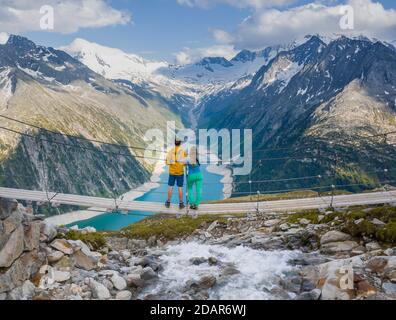Randonneur, jeune femme et jeune homme sur le pont suspendu à Olpererhuette, réservoir Schlegeis, réservoir Schlegeis, Alpes de Zillertal, Schlegeiskees Banque D'Images