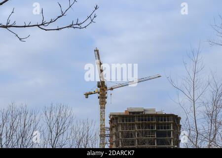 Construction d'un immeuble résidentiel de plusieurs étages. Grue près d'une maison inachevée. Banque D'Images