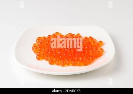 Caviar rouge sur une assiette blanche. Source de gras, de protéines et de glucides. Banque D'Images