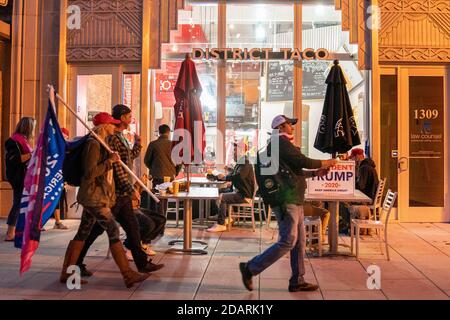 Washington, États-Unis. 14 novembre 2020. Les partisans du président pro-Trump qui font partie de la « Million MAGA March », se promondent devant le restaurant District Taco après leur marche devant la Cour suprême plus tôt à Washington, DC, le samedi 14 novembre 2020. Certains membres du personnel du président Trump poussent à le maintenir au pouvoir malgré une victoire évidente pour le président élu Joe Biden lors de votes électoraux et populaires, ce qui provoque une crise de sécurité nationale. Photo de Ken Cedeno/UPI crédit: UPI/Alay Live News Banque D'Images