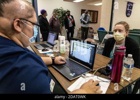 Jen Finch, 40 ans, de Holland, Ohio, prend les informations d'un professionnel de la santé qui se tient pour un patient au centre de test local de la NHA COVID-19 dans l'église chrétienne de la Grande grâce.Neighborhood Health Association (NHA) s'associe à l'église chrétienne de la Grande grâce (GGCC) dans le quartier Auburn-Delaware de Toledo, Ohio, GCC Donner aux résidents de la région l'accès aux tests de laboratoire COVID-19 et à la garde-manger de l'église. NHA a fourni plus de 100 tests COVID-19 à la communauté, et le GGCC a permis aux résidents de partir avec des paniers pleins de provisions. Banque D'Images