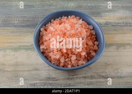 Sel rose himalayan dans un petit bol à condiments bleu sur la table Banque D'Images