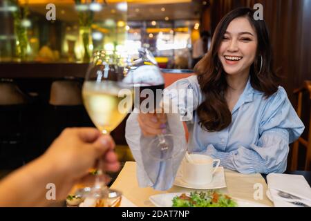 la jeune femme et son couple font des encouragements avec des lunettes de vin au restaurant Banque D'Images