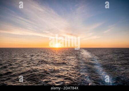 Lever du soleil sur une mer Méditerranée calme, vue depuis la poupe d'un bateau de croisière. Banque D'Images