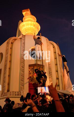 Les manifestants pro-démocratie grimpent sur le monument de la démocratie en utilisant une échelle pour accrocher un énorme feuillet blanc rempli de messages de protestation pendant la manifestation.les manifestants pro-démocratie se sont tournés vers un rassemblement sur le thème du carnaval nommé « Mob Fest » au monument de la démocratie demandant la démission du Premier ministre Prayut Chan-O-Cha, une nouvelle constitution et des réformes de la monarchie. Banque D'Images