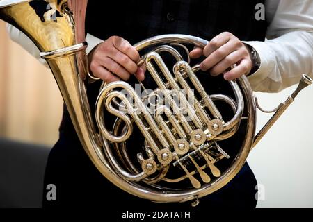 Un musicien tient une corne française pendant un concert de un ensemble de vent Banque D'Images