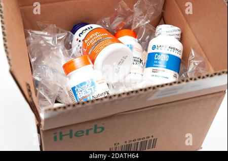 Ouvrez la boîte en carton contenant les suppléments et les vitamines de la boutique en ligne iHerb. Banque D'Images