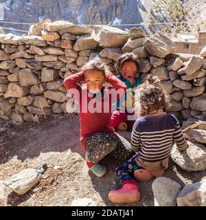 Manang, Népal - 11 novembre 2015 : trois enfants népalais jouent dans la rue du village Banque D'Images