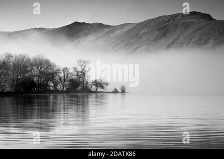 La brume plane sur la surface du lac, mais les montagnes s'élèvent clairement au-dessus Banque D'Images