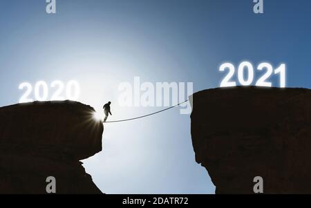 2021 nouveau concept de l'année, silhouette d'un homme marchant sur corde de 2020 à 2021 Banque D'Images
