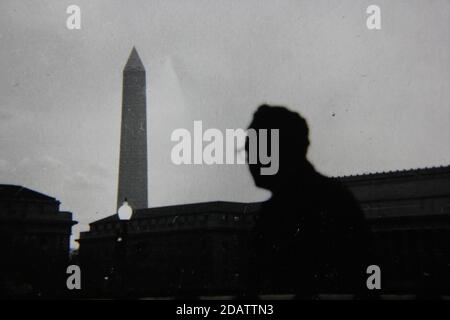 Belle photographie en noir et blanc vintage des années 1970 de la silhouette d'un touriste qui regarde le Washington Monument. Banque D'Images